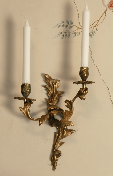 2 st rokoko appliker i mässing. 2 assymetriska ljusarmar i form av bladslingor. Ljusmanschetter i form av blommor under ljuspipor med bladdekor.