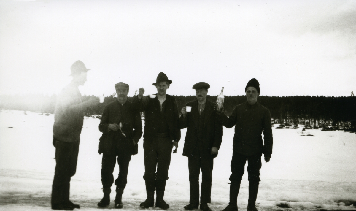 5 menn stående i snøen m/flaske og glass ved Håkkåmakk. Petter (P.A.) Galaasen (5/12 1887 - 1952) el. Peter Galaasen (1886 - 1949), Lars Bjørkli (4/2 1868 - 1956), Karl Andersen og svenskene Ågren og Sjøgren