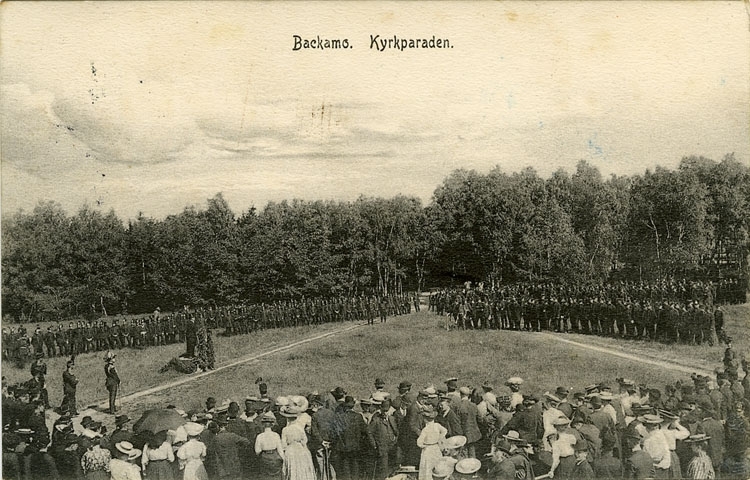 Enligt Bengt Lundins noteringar: "Backamo. Kyrkparad 1907 med talarstol och stor publik".