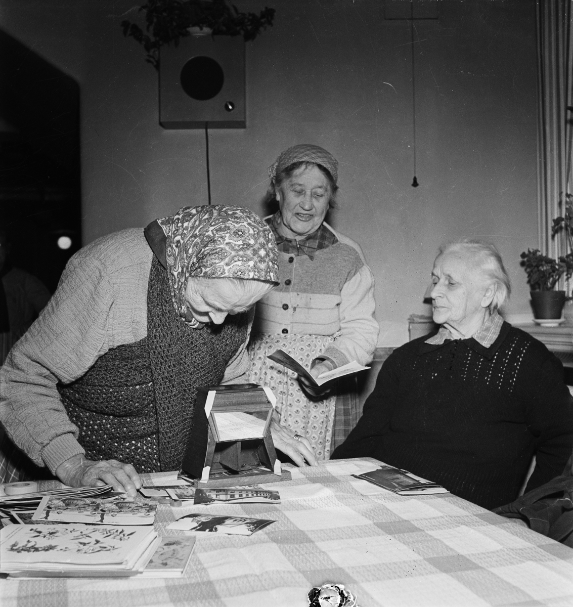 Några kvinnor på Uppsala Ålderdoms- och Sjukhems sjukavdelning studerar ett gammlat tittskåp