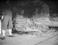 Mann ved peis, mura av gråstein, antagelig seterhus