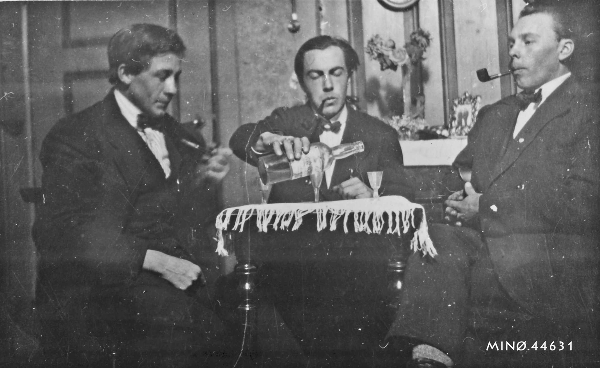 Tre piperøkende karer som koser seg med en dram