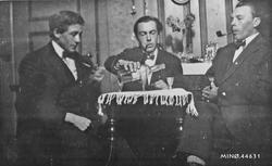 Tre piperøkende karer som koser seg med en dram