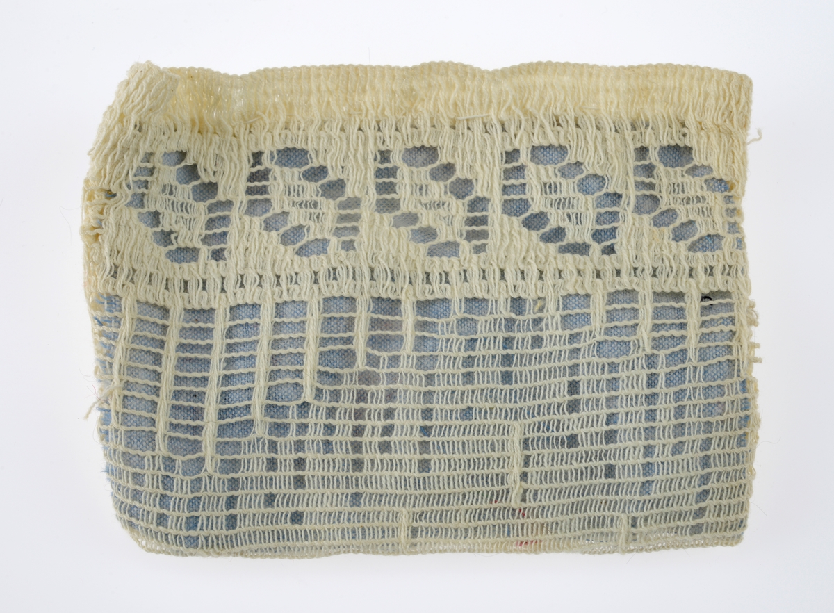 En sjokoladeeske brukt som dukkeseng med dukke, dyne, pute, skinnfell, ullteppe og madrass. Gjenstandene er undernummerert 01-08.
FTT.54432.01: En sjokoladeeske fra Freia brukt som dukkeseng. Esken er med lokk og laget av papp. Den er stiftet i hjørnene. Utenpå er det trykt julenissehoder i rødt og grønt. For tekst se "Påført tekst/merker".
FTT.54432.02: En dukke laget av plast der både armer og bein er bevegelige ved at de er festet med strikk inni dukken. Håret er støpt og er krøllet ved ørene. I ansiktet er det malt øyebryn, øyne, røde kinn og munn. Dukken har på seg en pyjamas laget av flanell. Den er stripete i fargene hvit, blå, lys oransje og grønn. På skjorten er det to knapper i fronten.
FTT.54432.03: En hodepute laget av blått bomullsstoff med heklet trekk. Puten er fyllt med diverse tekstilbiter.
FTT.54432.04: En dyne laget av blått bomullsstoff med en påsydd blondekant foran. Baksiden er sydd sammen av tre ulike tekstiler. Dynen er fyllt med tekstilbiter.
FTT.54432.05: En brunsvart skinnfell, trolig laget av kaninpels.
FTT.54432.06: Et ullteppe som trolig klippet ut av et eksisterende ullteppe. Teppet er gulhvitt med blomster og blader i rosalilla.
FTT.54432.07: Et sammenbrettet stykke som er heklet. Trolig en rest som er brukt som madrass i esken/sengen.
FTT.54432.08: Et sammenbrettet stykke som er heklet. Trolig en rest som er brukt som madrass i esken/sengen.