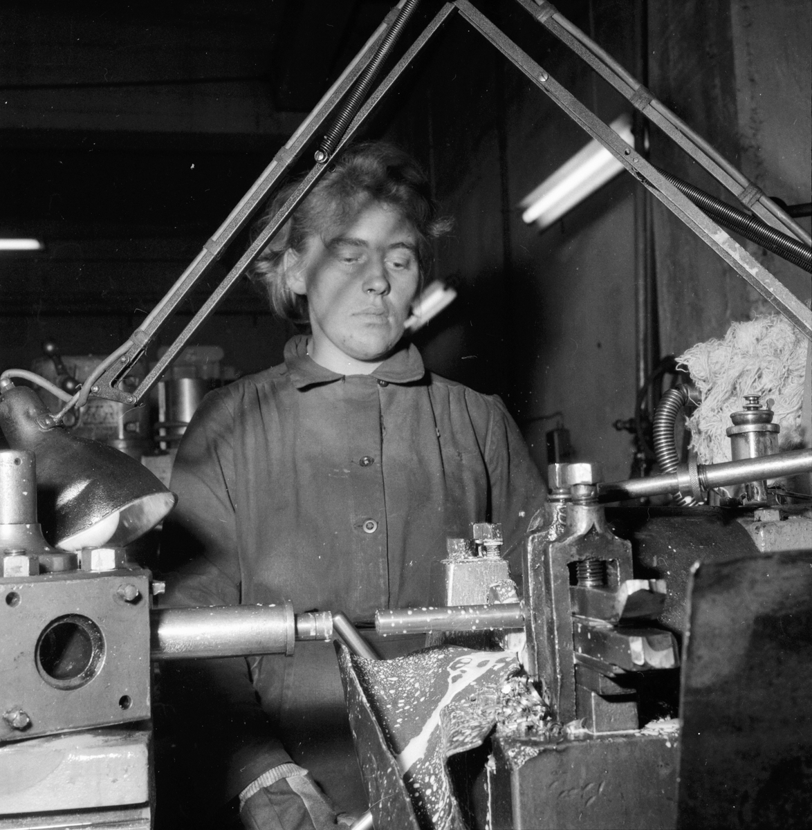Lingbo verkstäder.
Eva Rasmusen svarvar kedjehylsor i en automatisk svarv som averkar hela stången i ett enda moment.
13/11 1958