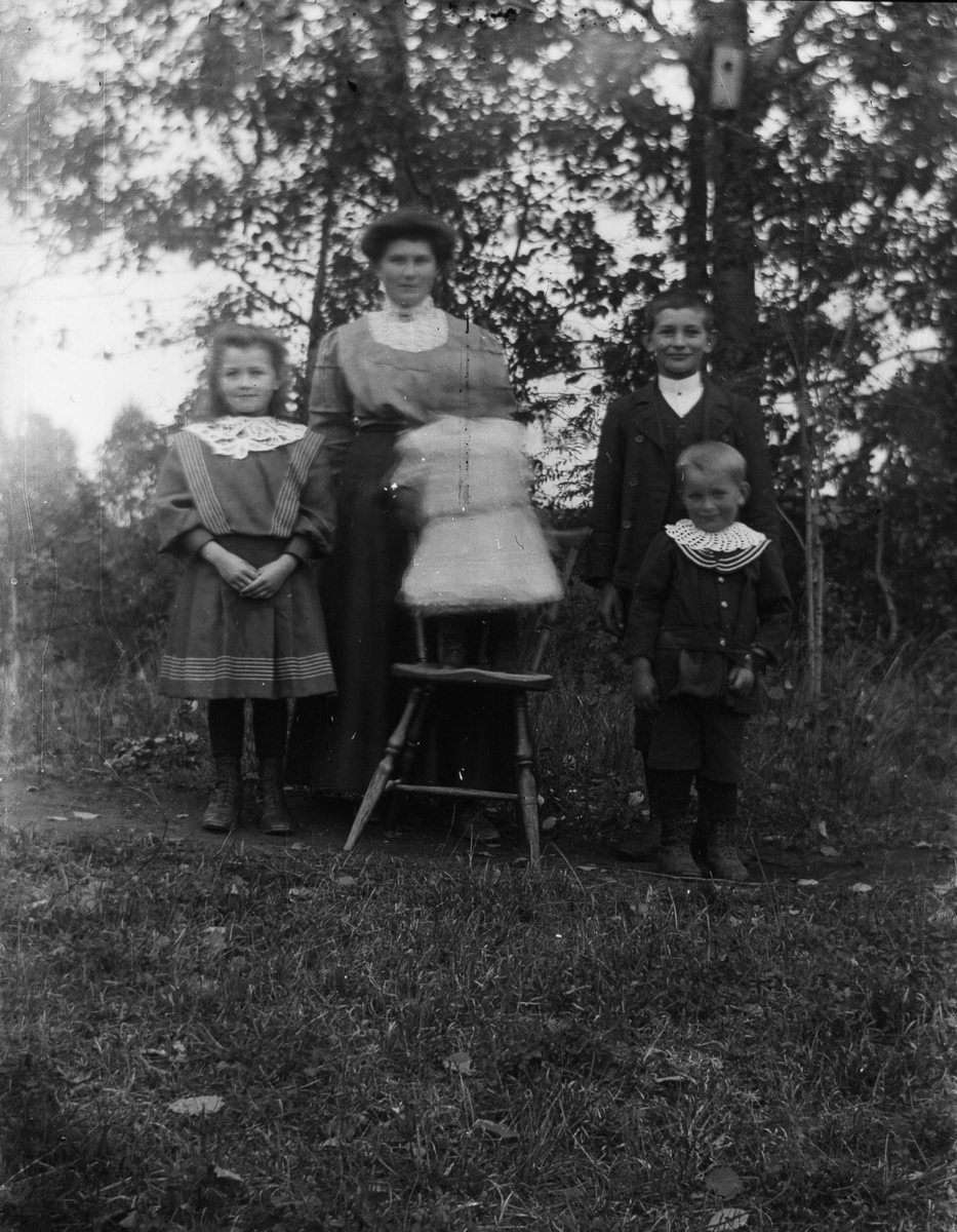 Kvinna och fyra barn samlade för fotografering.
