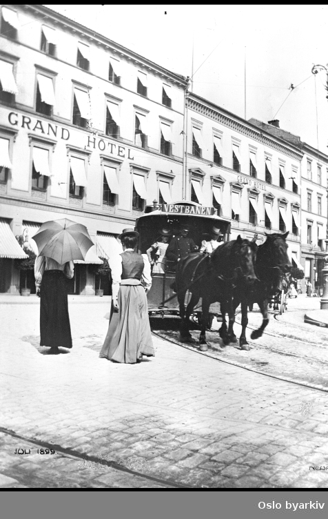 Hestesporvogn utenfor Grand Hotel. Hestesporvognen i Oslo kom i 1875. Hestesporvogn med to hester og dobbelspor. Grand hotel med gammel fasade før 1913. Anlagt ledninger for elektrisk sporveier. Bildet datert 1899.