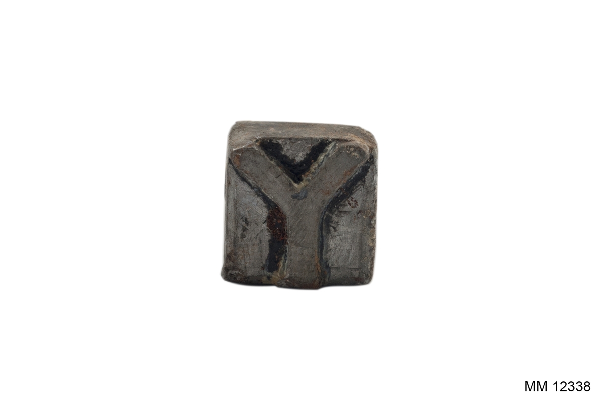 Stämpel för klädespersedlar. Av vitmetall med trähandtag.
Stämpelns utseende: "Y".