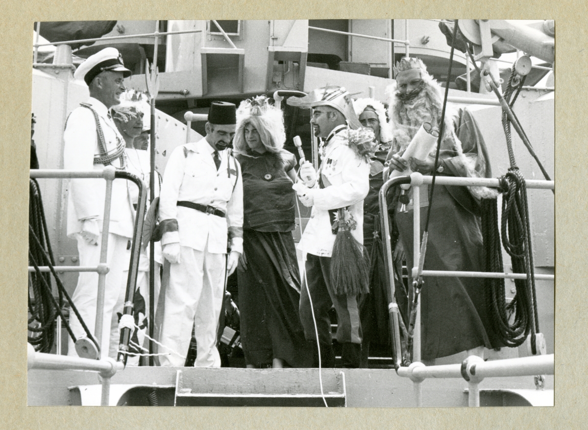 Bilden föreställer en grupp män utklädda till kung Neptun och hans hov under ceremonierna kring ett linjedop ombord på minfartyget Älvsnabben i samband med långresan 1966-1967.