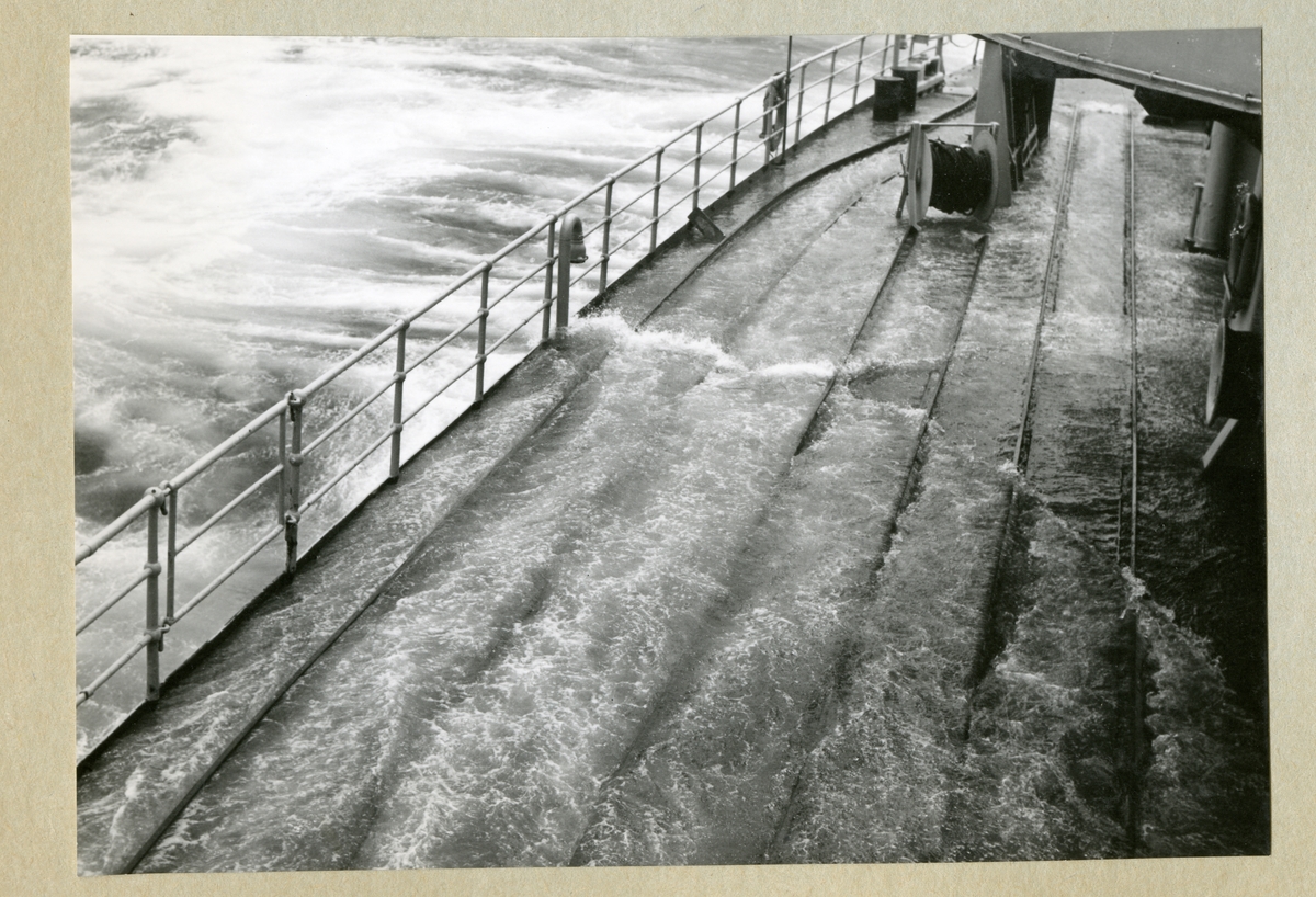 Bilden föreställer minfartyget Älvsnabbens däck fyllt med vatten till följd av stormigt vatten i samband med orkanen Diana. Bilden är tagen under fartygets långresa 1966-1967 i Tasmanska sjön på väg mellan Sydney och Wellington.