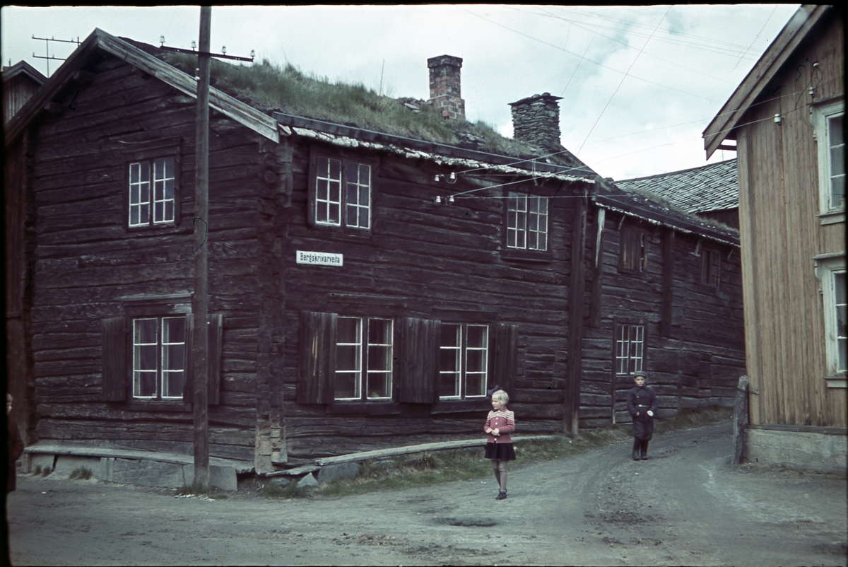 En jente og en gutt foran Ole Salvesens sykkelverksted på hjørnet av Bergskriverveta og Finneveta på Røros.