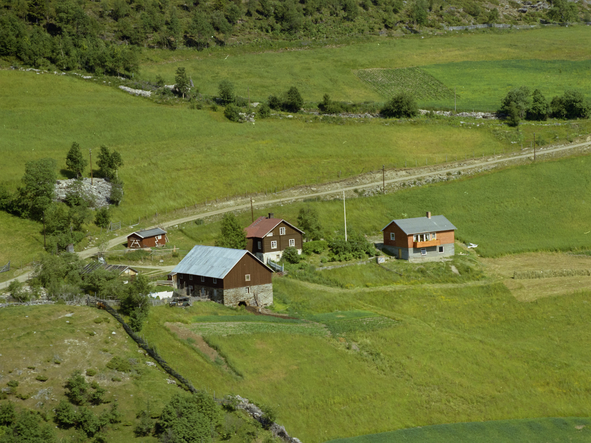 Sør-Fron, Hundorp, Midtre Øverbygda. Gården Haugsjordet. Bygdeveg, dyrket mark og en stripe granskog øverst.