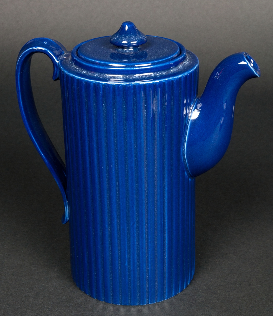 Kaffekanna med lock i cylinderform. Räfflad dekor och med stark blå färg. Ostämplad. Formgiven av Arthur Percy vid Gefle Porslinsfabrik, 1950-tal. 
Hör samman med gräddkannan 35786.