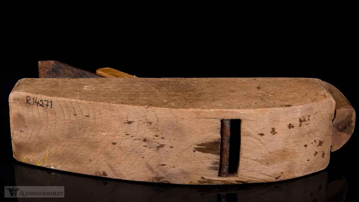Rektangulær høvelstokk med kraftig buet såle og horn som er felt inn og skrudd fast i forkant. Trapesformet høvelhus med jern med klaff og kile.