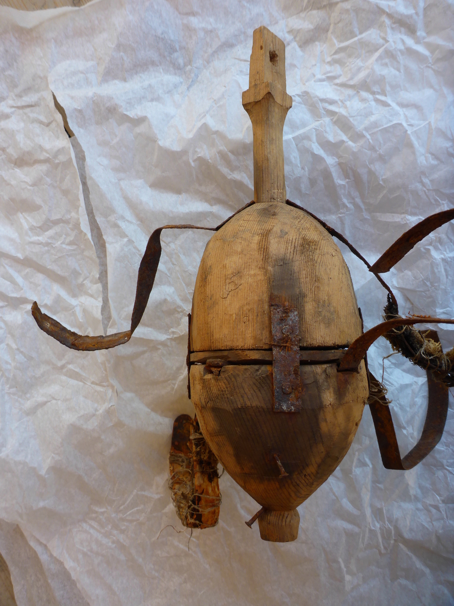 Håndlaget lysekrone med åtte armer.
Torsoen er sylindrisk og er konet i begge ender, og den er satt sammen av tre deler. Armene og lysholdere er laget av blikkbånd. Lysholderne er loddet. Det sitter igjen rester av avispapir og mose på noen an av armene. Dette er festet med hyssing.