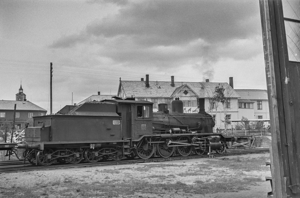 Damplokomotiv type 18c nr. 233 i sydgående godstog på Røros stasjon. I bakgrunnen gamle Bergstadens hotell.