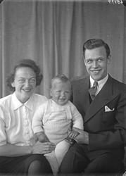 Portrett. Familiegruppe på tre. Mor, far og liten gutt.  Bes