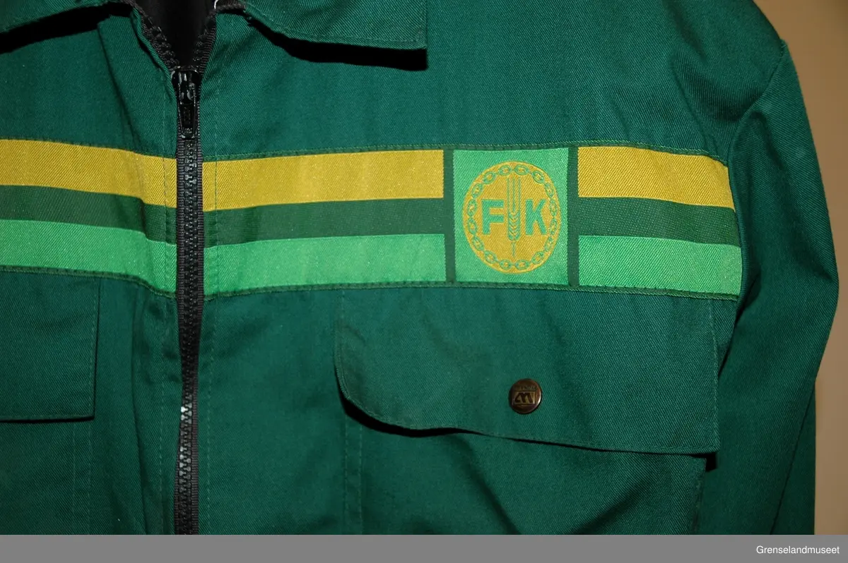 Kjeledress i tre deler, bukse, jakke, skyggelue. jakke st. 54, grønn med gul og lys grønn stripe, bukse grønn, skyggelue blå, st. 59.
Syntetisk stoff