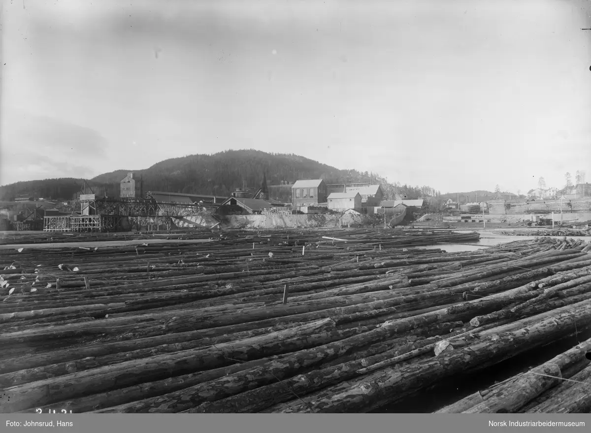 Tømmer liggende i vannet ved Tinfos Jernverk og Karbidfabrikken.