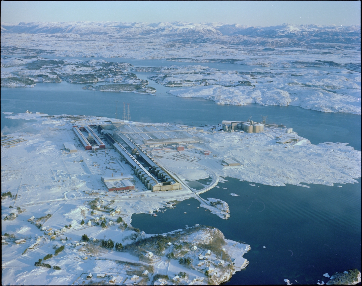 Flyfoto av Norsk Hydro sitt aluminiumsverk på Karmøy en vinterdag. Bildet er tatt mot øst med Røyksundkanalen i bakgrunnen.