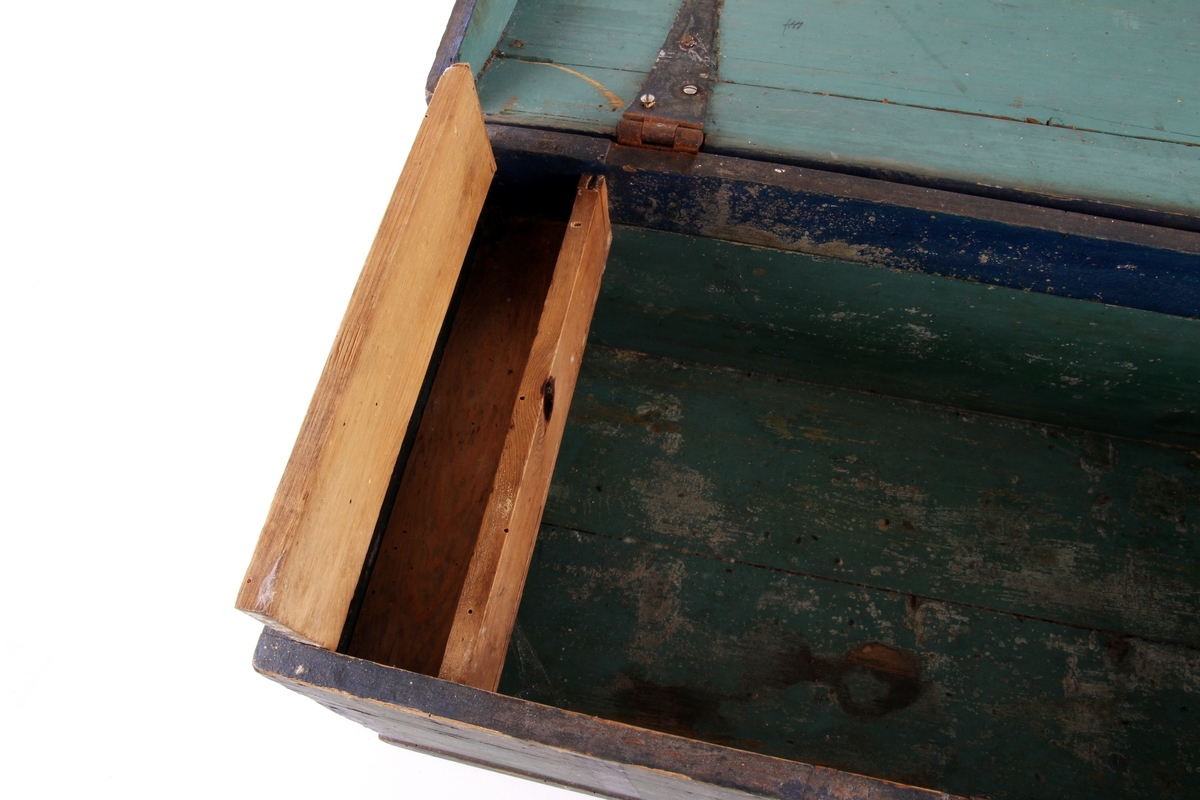 Grønnmalt trekiste med hjerteformet låsbeslag skåret ut i tre. Lås og hengsler i metall. Kisten har leddik med lokk innvendig.