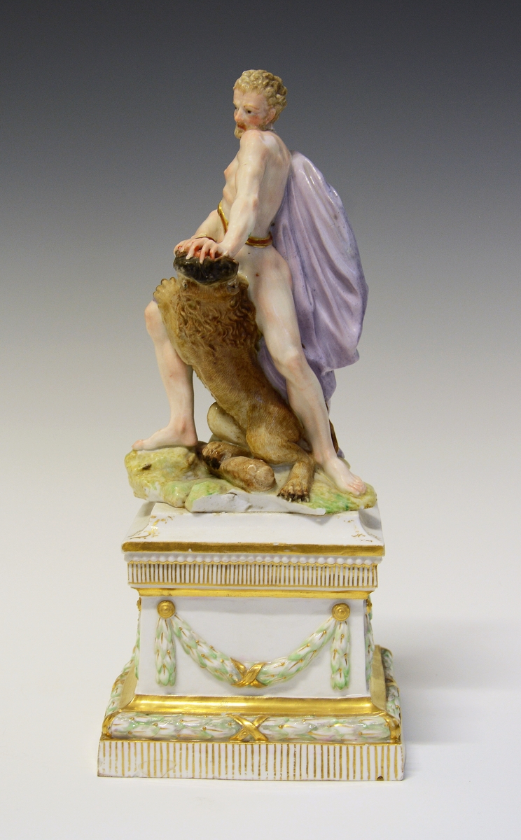 Herkules slåss mot en løve med bare hendene. Hans atributt, klubben ligger ved hans føtter, delvis under løven. De står på en underlag som imiterer gress. Under dette en kvadratisk sokkel med laurbærgirlandere i nyklassisistisk utførelse.