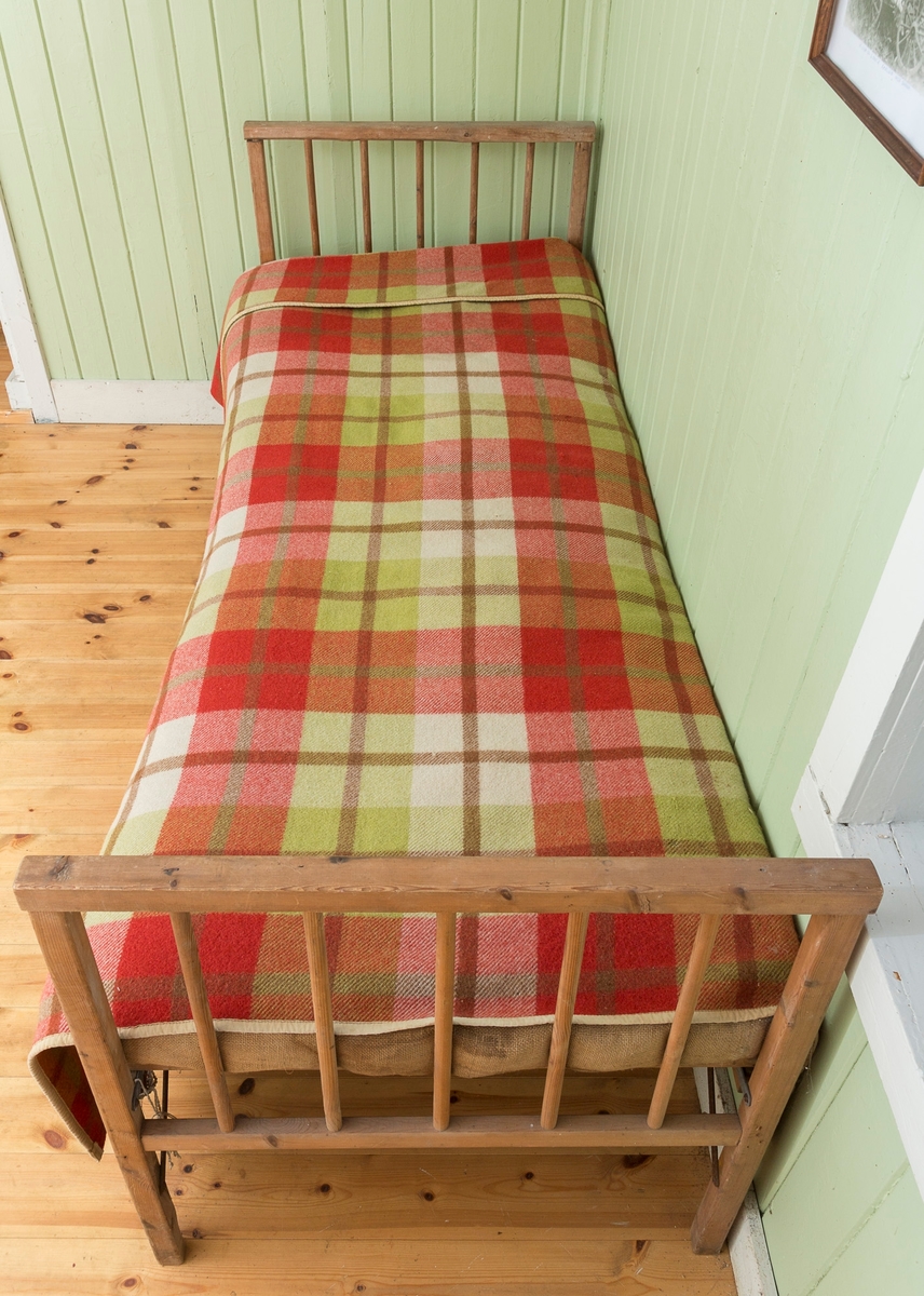 Sengeramme med sangegavler bestående av staver. Ubehandlet tre. Avstivere i metall. Nettingbunn.