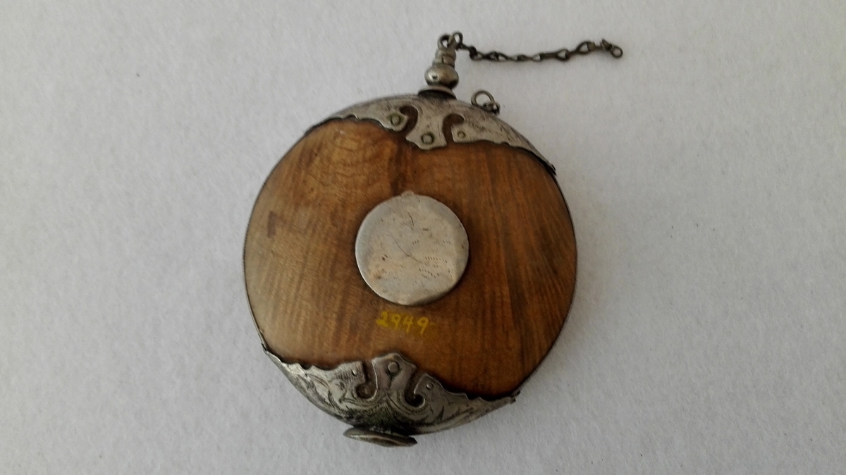 Form: Flattrykt, rund, dreia av lauvved og vakkert sølvbeslått. Kjøpt 7/6 1899 på Øye i Lærdal.