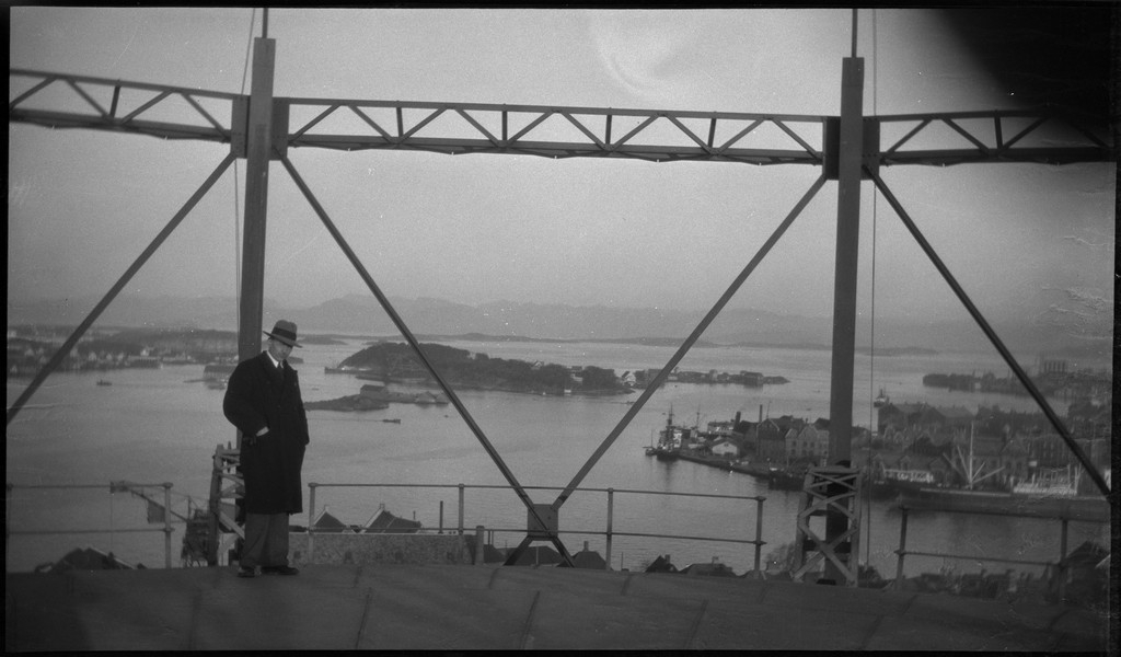 Per Årseth (bilde 1)  og en annen mann (bilde 2) ser ut over Stavanger fra toppen av en gassverkbeholder.