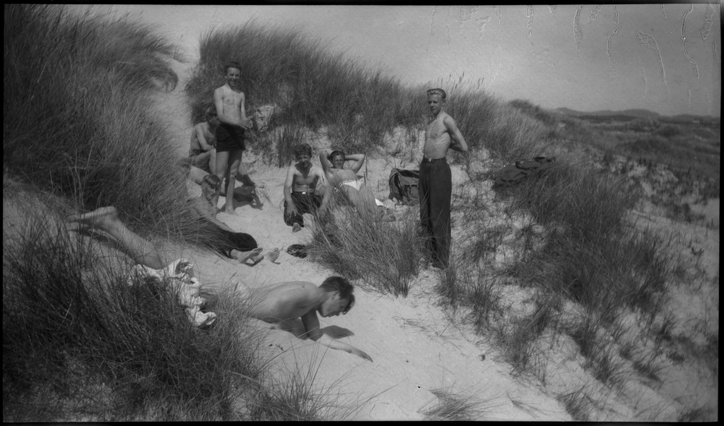 En gjeng med unge menn på sykkeltur langs en strand på Sola. Det er også bilder fra en pause og lek i sanddynene. Lintner er oppe til venstre på bilde nr. 4.