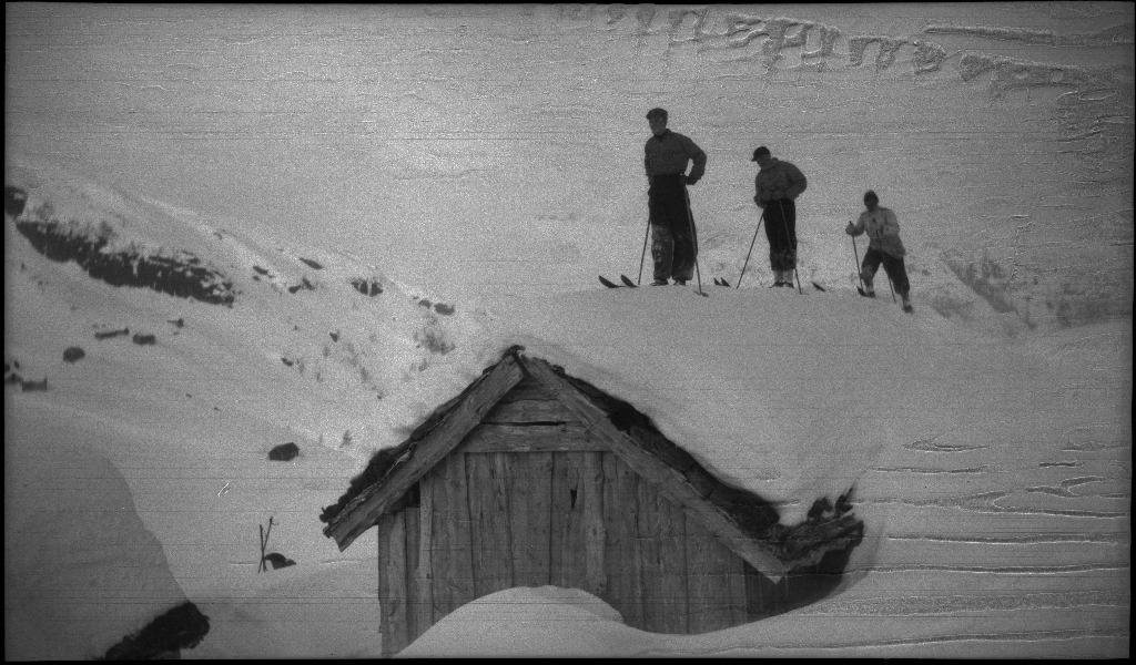 En guttegjeng på skitur i fjellene ovenfor Saudasjøen. Det er bilder av gjengen som går oppover bakkene, og fra en pause ved en gammel hytte.