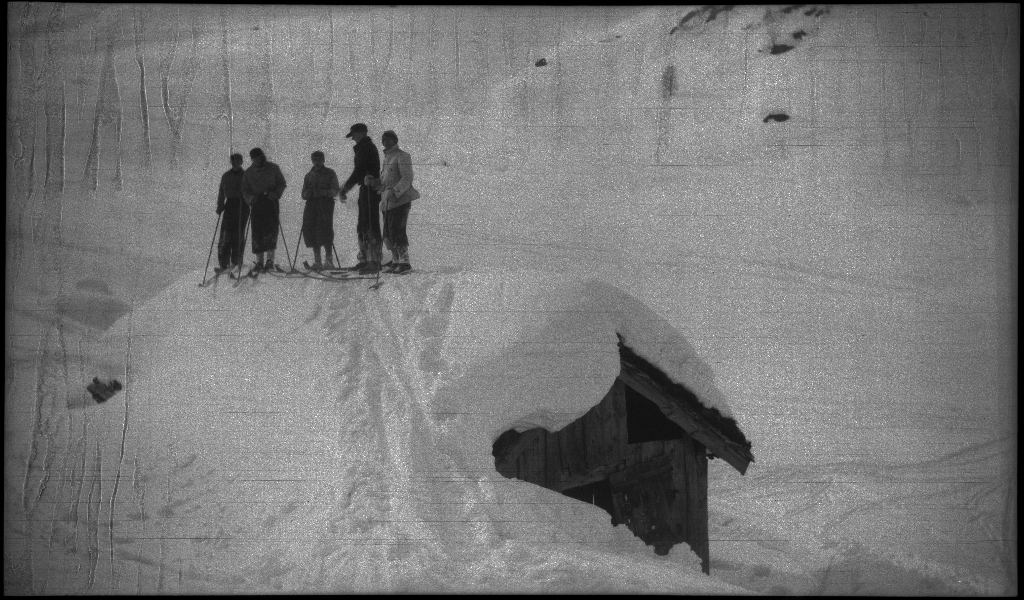 En guttegjeng på skitur i fjellene ovenfor Saudasjøen. Det er bilder av gjengen som går oppover bakkene, og fra en pause ved en gammel hytte.