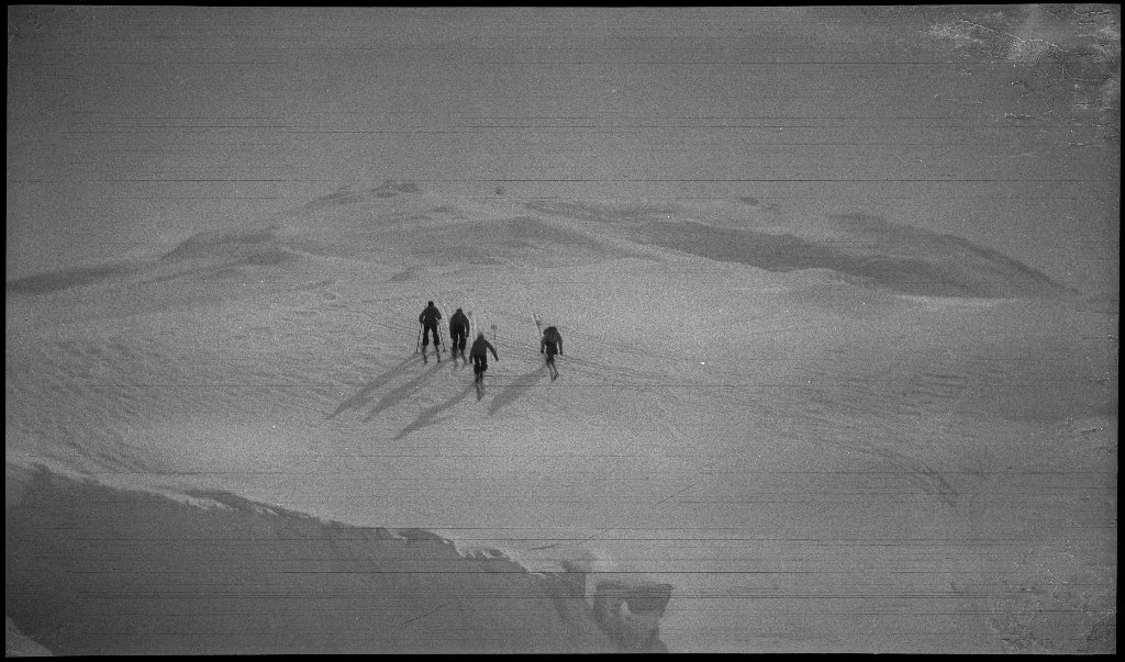 Fire unge menn på skitur påsken 1936. De har laget en bil av snø med bobleform (kanskje inspirert av Porsche Typ 1 fra 1935). Det er også bilder fra flere fjelltopper, fra skigåing og fra ei turisthytte.