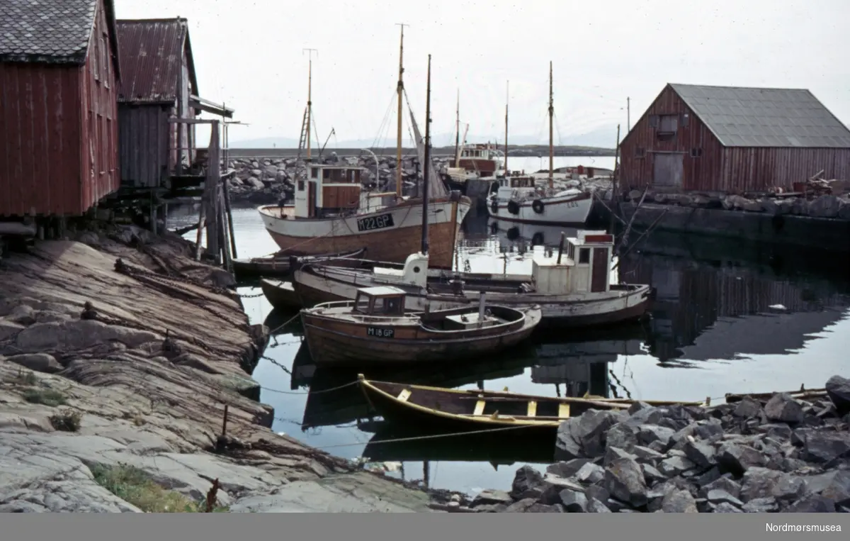 Foto fra båthavna på fiskeværet Grip, nå i Kristiansund kommune. Fotograf er Kjell Haug og er den som står bak samlingen med fargefoto/dias fra Kristiansund og Grip. Bildene dateres til omkring 1950-1970. Fra Nordmøre museums fotosamlinger.