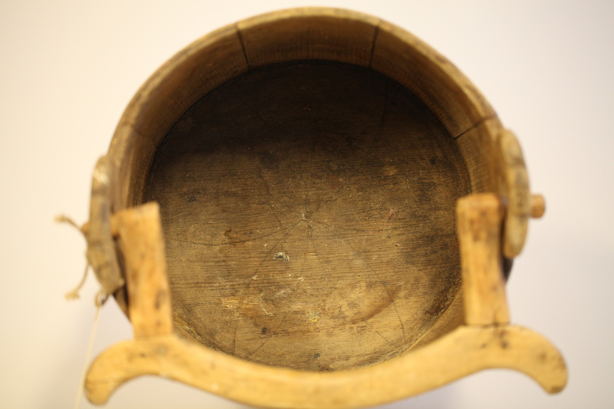 Lagget med 2 gjorder, men den øverste er borte. Bevegelig tverrhank med tretapper, to ører og innfelt bunn. Formen er rund, sylinderformet, uten lokk eller ben. Har vært påmalt rød farge. Brukt til melk.