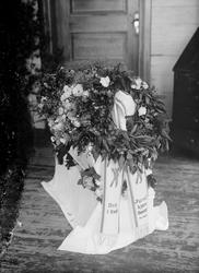 Begravelse. Hjørdis Jevnes båre. Hvit kiste med blomsterkran