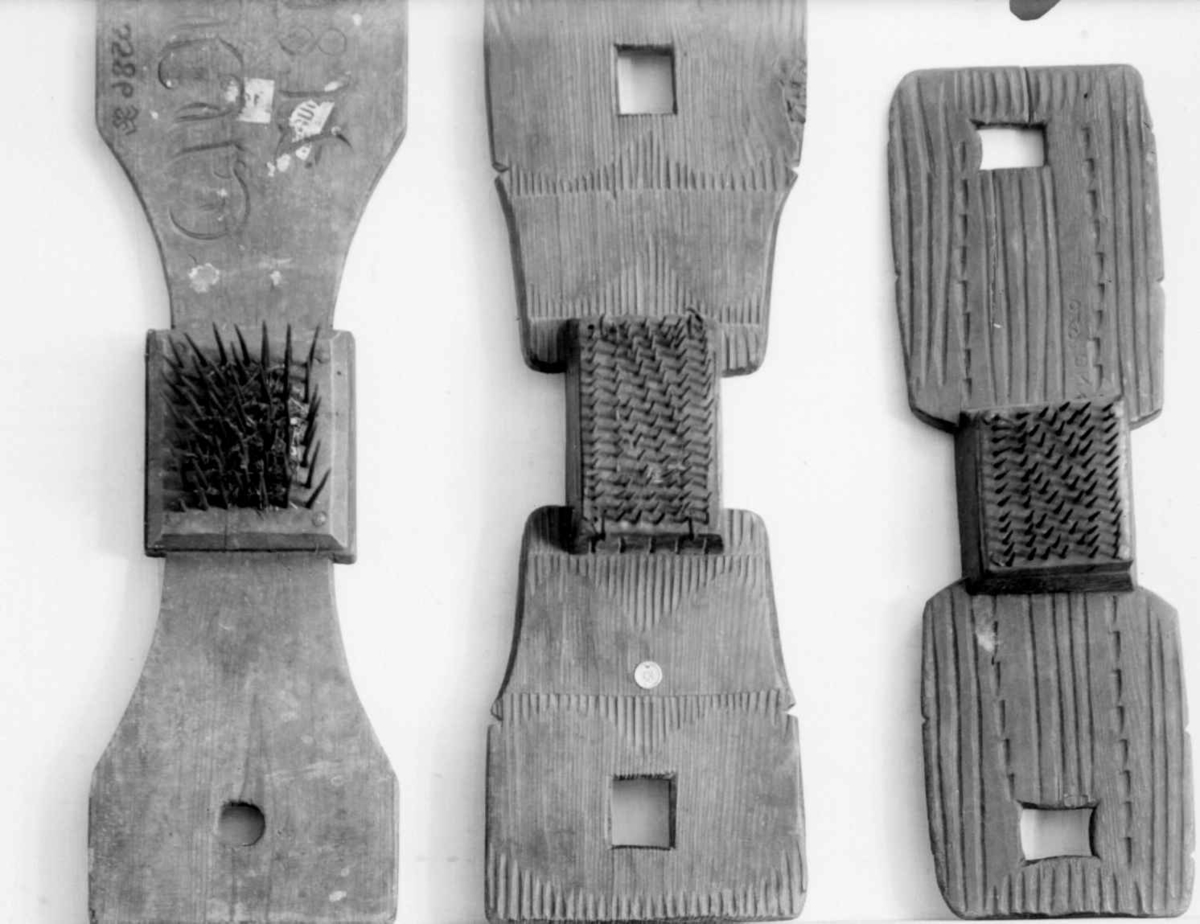 Hampehekle av tre med kvadratiske hull i hver ende. På midten er det festet en trekloss med stålnagler.