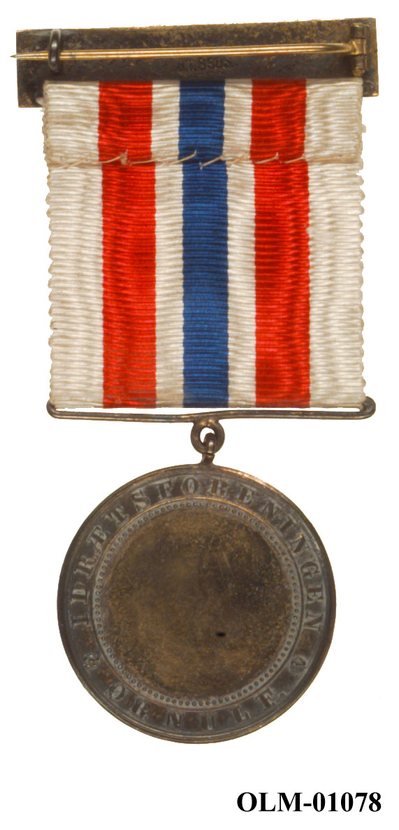 32 forskjellige medaljer og merker i ramme.
Bilde 7 er deltdagermerke fra Amsterdam 1928.
Bilde 18 og 19 er deltagermedalje fra Amsterdam 1928.
Bilde 20 og 21 er sølvmedaljen fra Antwerpen 1920.
Bilde 26 og 27 av bronsemedaljen fra Paris 1924.
Bilde 39 og 40 minnemedaljen fra Antwerpen 1920.
