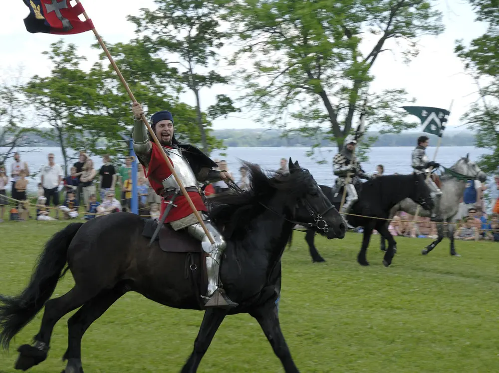 Medieval Knight riding horseback, holding a banner.