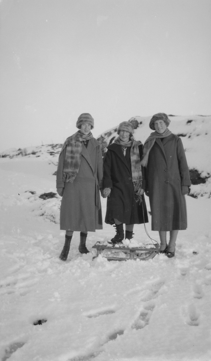 Tre kvinner med en kjelke