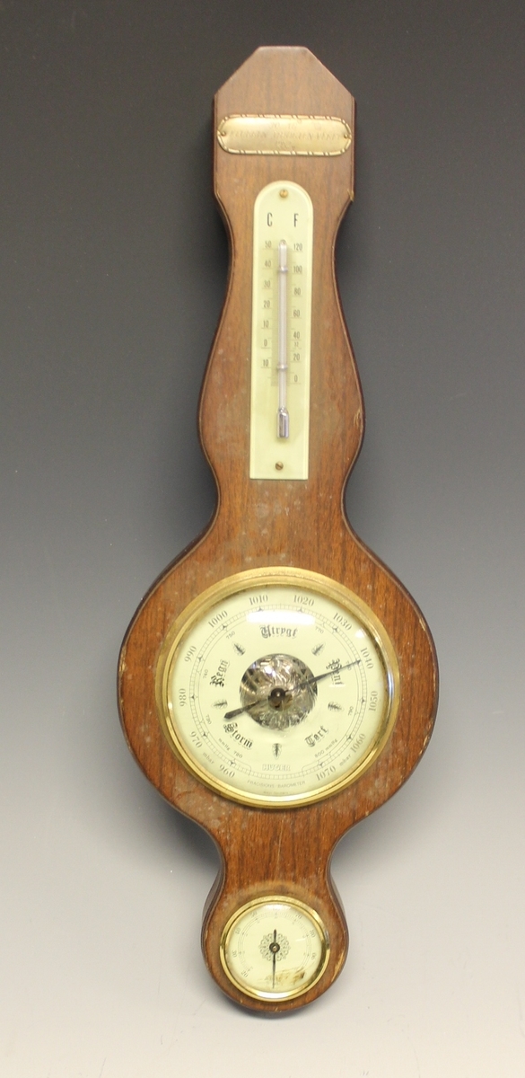 Barometer med svungen former. Termometer er skrudd fast øverst og hygrometer er innfelt nederst. Veggfeste.