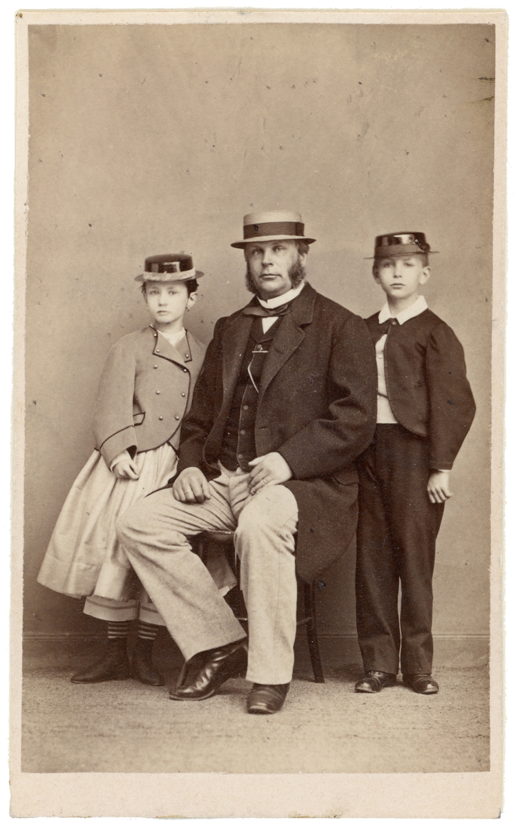 Porträtt av doktor Ludvig Åman med barnen Erik och Ellen. Denne var från 1852 allmän läkare för att 1854 bli lasarettsläkare i Linköping. Från 1860 fungerade han även som fängelseläkare i staden och från 1869 även som kurhusläkare. Gift med Fanny Nordvall.
