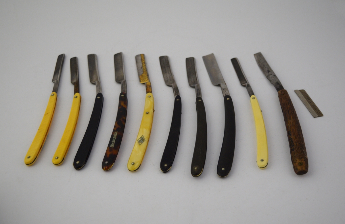 8 sammenfellbare barberkniver i kvadratisk læretui med adskilte lommer, 2 løse barberkniver og ett løst barberblad.