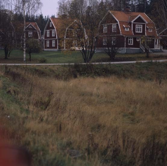 Villaraden i Sibo, oktober 2000. Tre stora boningshus ligger på rad nära en väg. De är röda med vita knutar och brutna tegeltak.