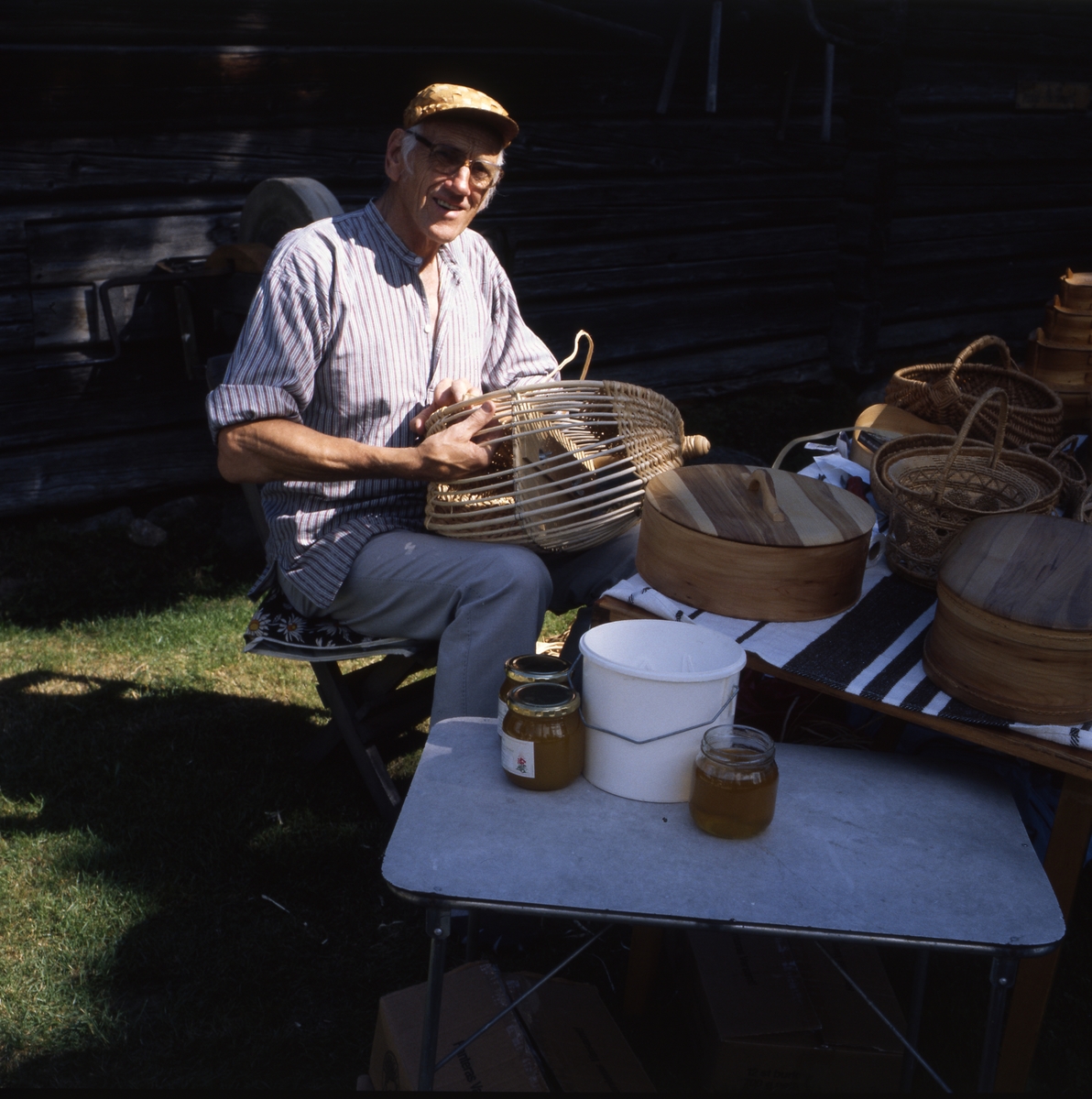 Rengsjöfesten 11 juli 1999. En man sitter och tillverkar en korg i rotslöjd.