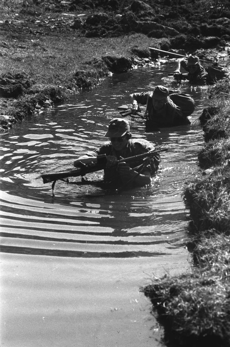 BSIN Patruljemarsj juni 1976. Befalsskolelever tar seg frem i en grøft full av vann.