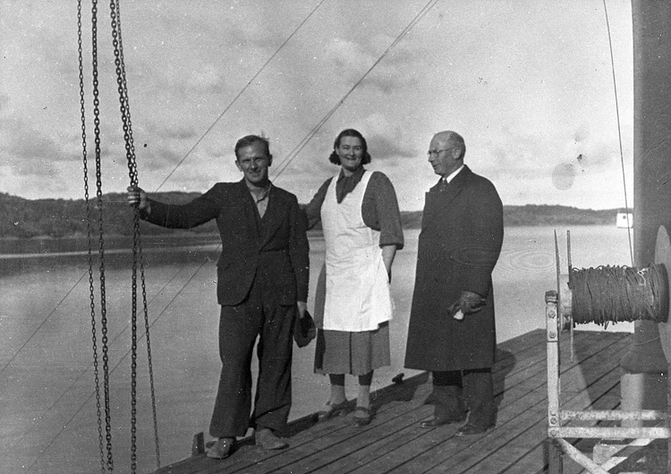 Enligt uppgift: "Fotografi år 1941 från övre bryggan vid stationsbyggnaden. På bilden syns från vänster Oscar Åkermo, Jenny Fagerberg (husmor på stationen) och August Nilsson (trålmästare)".