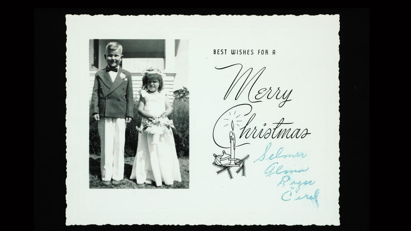 To barn avbildet på et julekort med julehilsen. Barna er pent kledd og bildet er ca. datert til 1960-tallet.