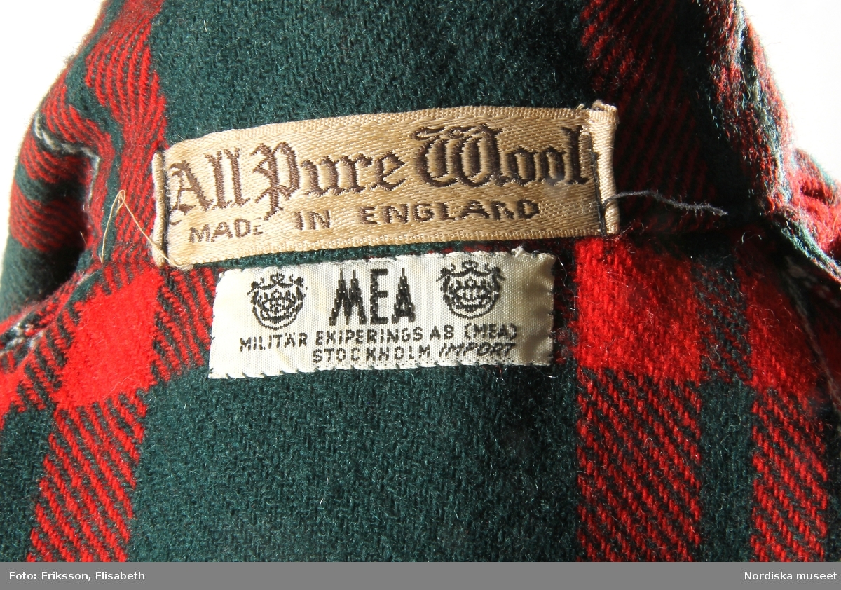 Morgonrock, 1950-60-tal, engelskt fabrikat av kyprat skotskrutigt ylle.
Grön botten med rutor i rött, vitt och svart. 1 bakstycke, 2 framstycken. Krage med 2 rundade slag. Knytskärp i midjan. 1 påsydd ficka på var sida. Ärmarna med påsytt uppslag. 
Inköpt på MEA.