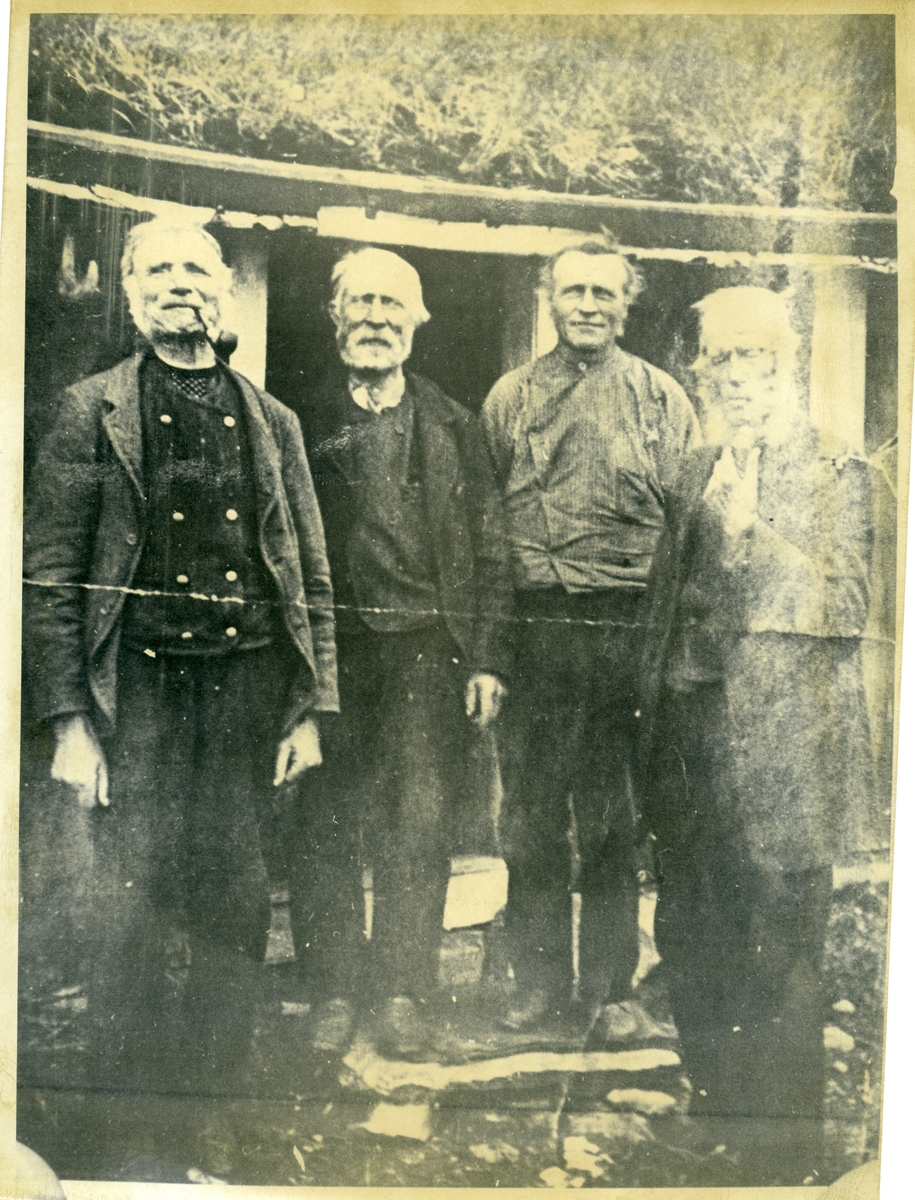 Bilde av 4 menn som står i døråpningen til et sel.